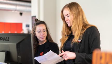 Fleur en Juni in gesprek met elkaar bij de balie van muZIEum