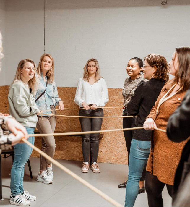 Bezoekers die allemaal een uiteinde van een touw vasthebben en proberen uit de knoop te raken.