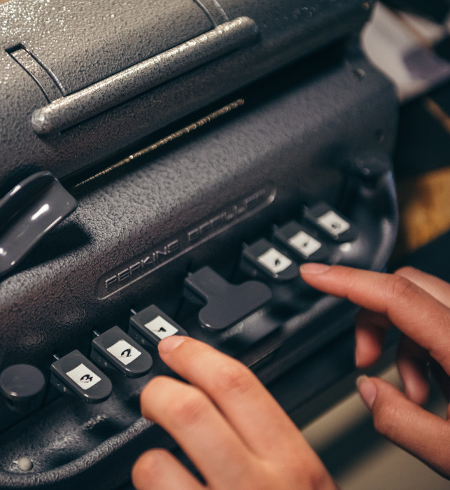 Een brailletypemachine, waarop een bezoeker braille probeert te typen.